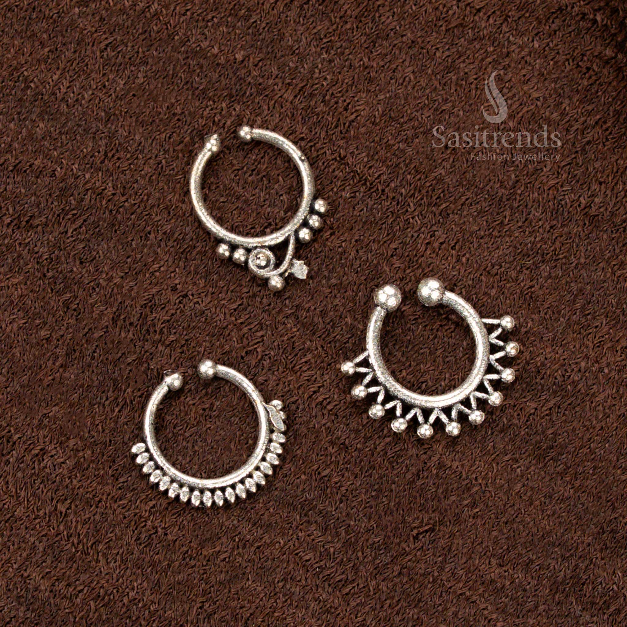 Traditional pressable oxidised nosepin with delicate floral bell design, finished in rustic silver and infused with temple-inspired beauty and a soft tribal touch by Sasitrends