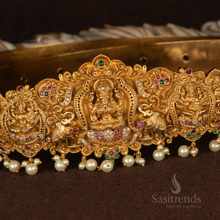 Heritage-inspired matte gold Lakshmi hip belt with intricate temple artistry, featuring peacock and elephant accents along with shimmering white pearl hangings for a divine ethnic look - Sasitrends