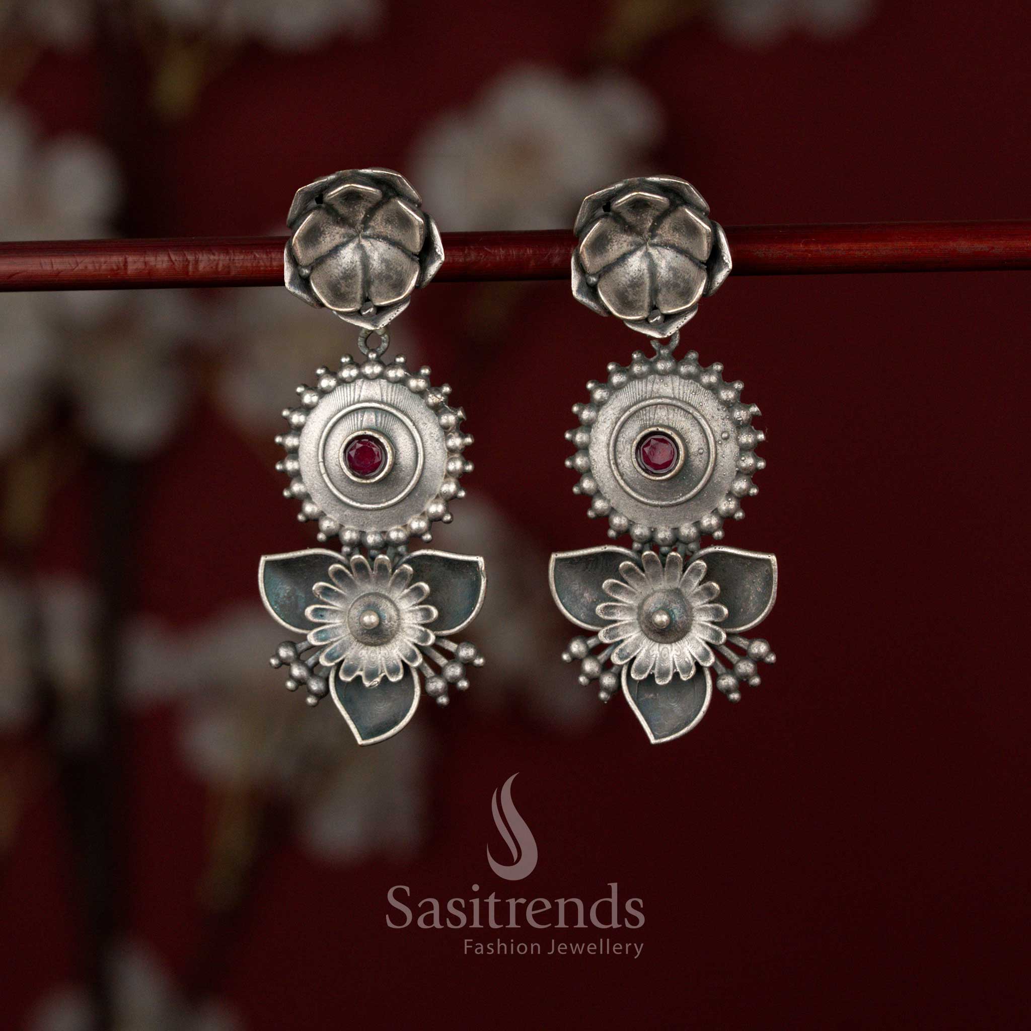 Sasitrends ruby oxidised German silver floral drop earrings featuring a layered disc design, textured stud top and intricate petal motif detailing, perfect for sarees, kurtis and festive styling.