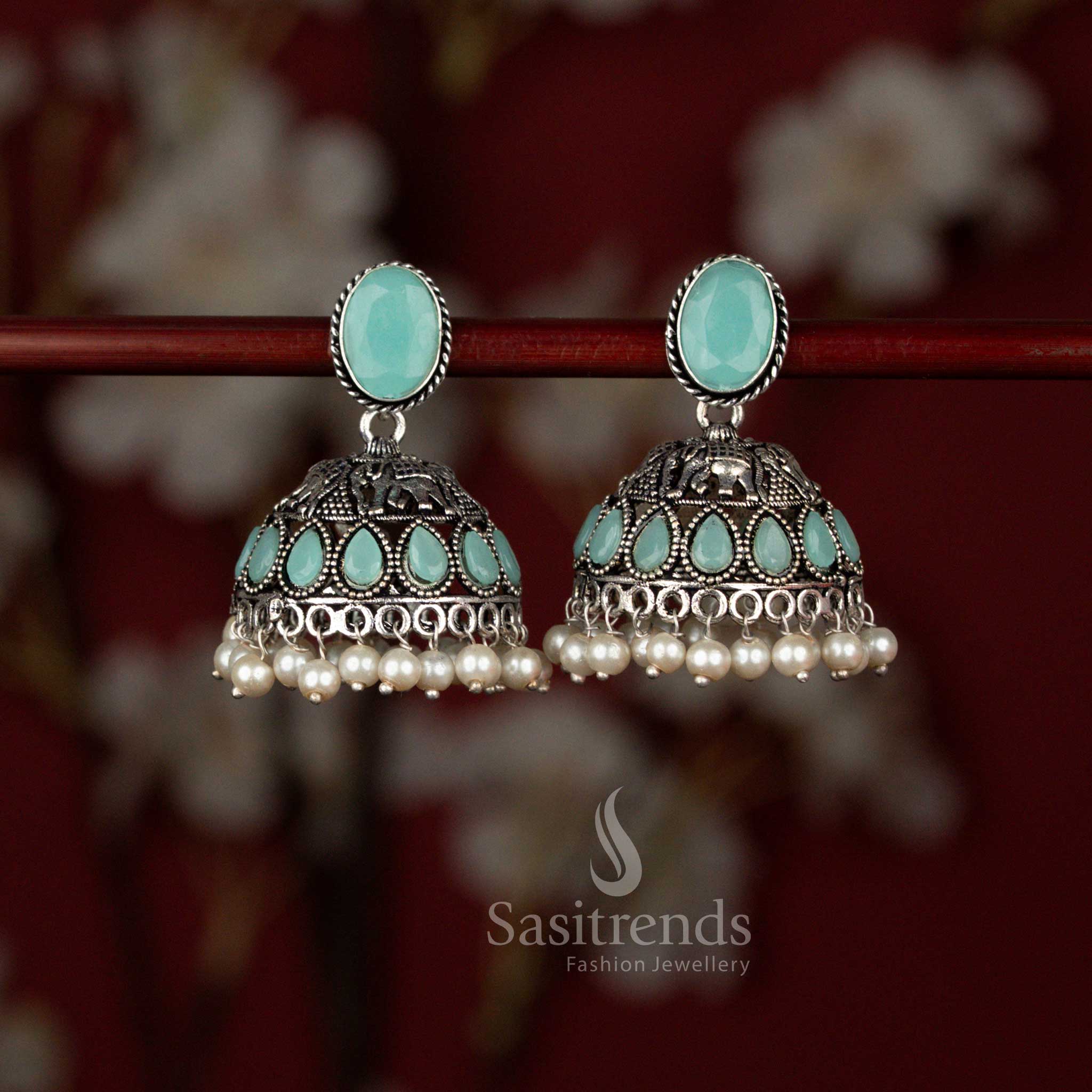 Sasitrends mint oxidised German silver jhumka earrings featuring a Monalisa oval stud, intricately carved elephant motif, radiant teardrop stone detailing and finished with elegant pearl drops for traditional and festive wear.