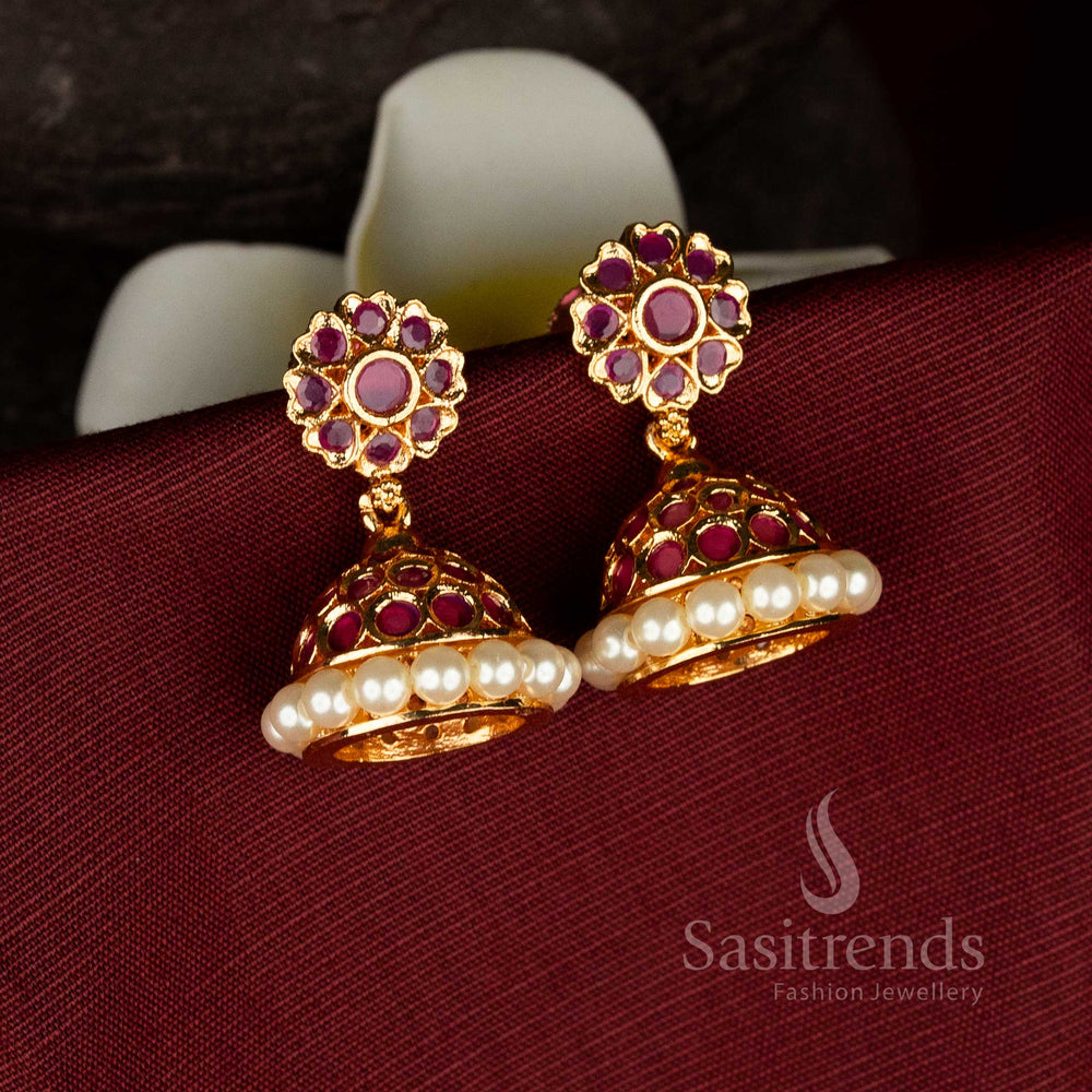 Traditional micro gold plated pearl jhumka earrings with dome shaped structure and detailed ruby American diamond stone work