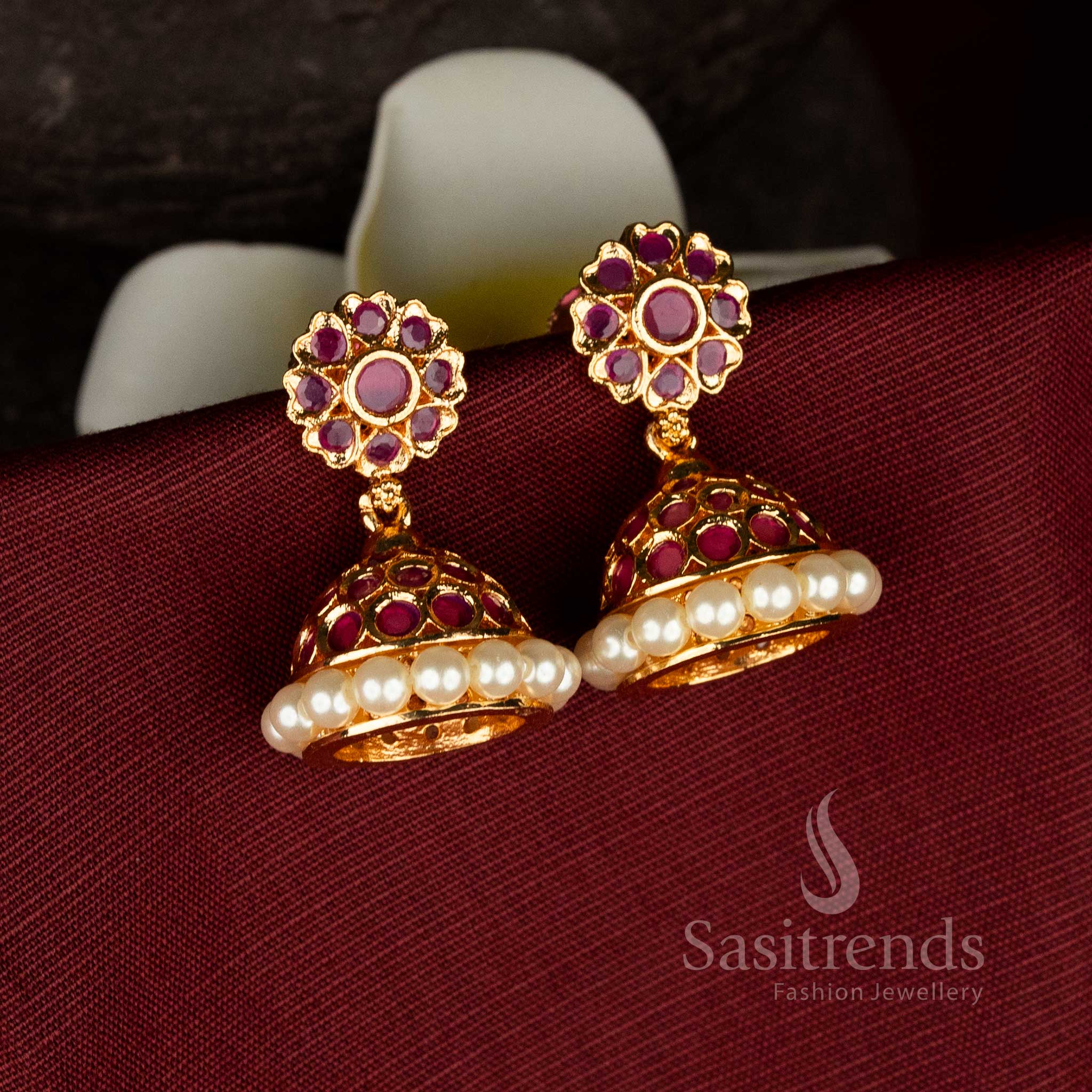 Traditional micro gold plated pearl jhumka earrings with dome shaped structure and detailed ruby American diamond stone work