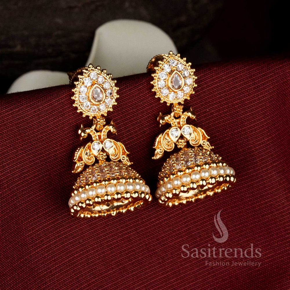 Traditional one gram micro gold plated earrings with teardrop stud design, dual peacock detailing, white American diamond stone work, and pearl jhumka base