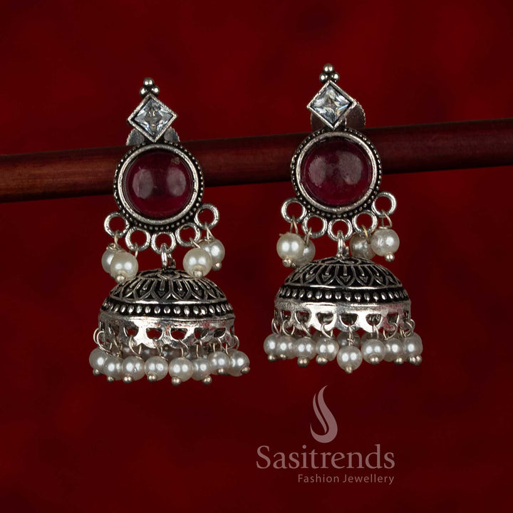 Sasitrends oxidised silver plated jhumka earrings featuring circular stud tops, layered dome structure with engraved detailing, and pearl bead hangings in a ruby and white color combination, suitable for ethnic wear, casual wear, office wear, and modern saree styling
