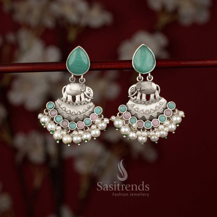 Sasitrends royal Majesty mint oxidised silver earrings featuring a detailed elephant motif framed within a crescent arc, highlighted by radiant teardrop stone embellishments and finished with elegant pearl hangings, perfect for Navaratri nights and traditional saree ensembles.