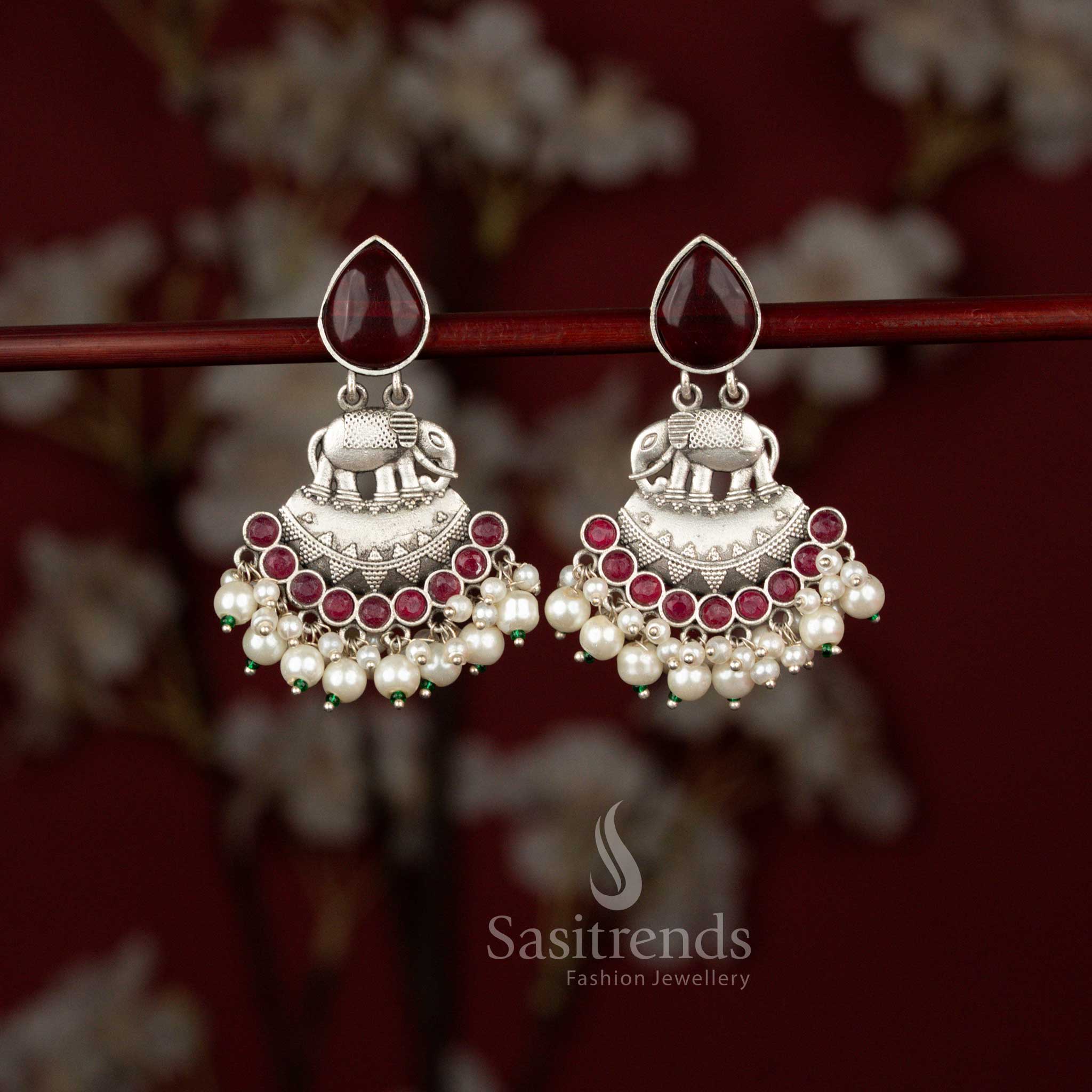 Sasitrends Majesty oxidised silver earrings designed with a majestic elephant motif set inside a sculpted crescent frame, enhanced with teardrop stone detailing and finished with elegant pearl hangings, ideal for Navaratri celebrations and saree styling.