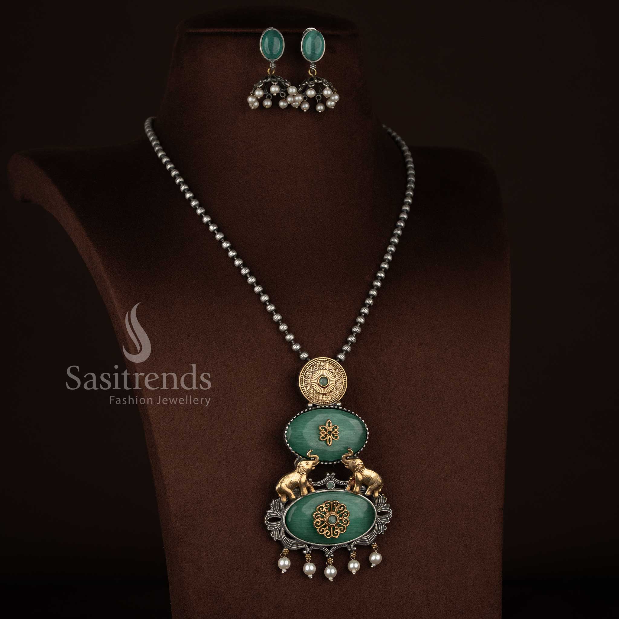 Sasitrends oxidised 92.5 silver plated necklace set designed with a vertical pendant structure showcasing embossed silver medallion, floral Monalisa panel, heritage elephant motifs, pearl drop detailing and coordinated earrings – mint colour option
