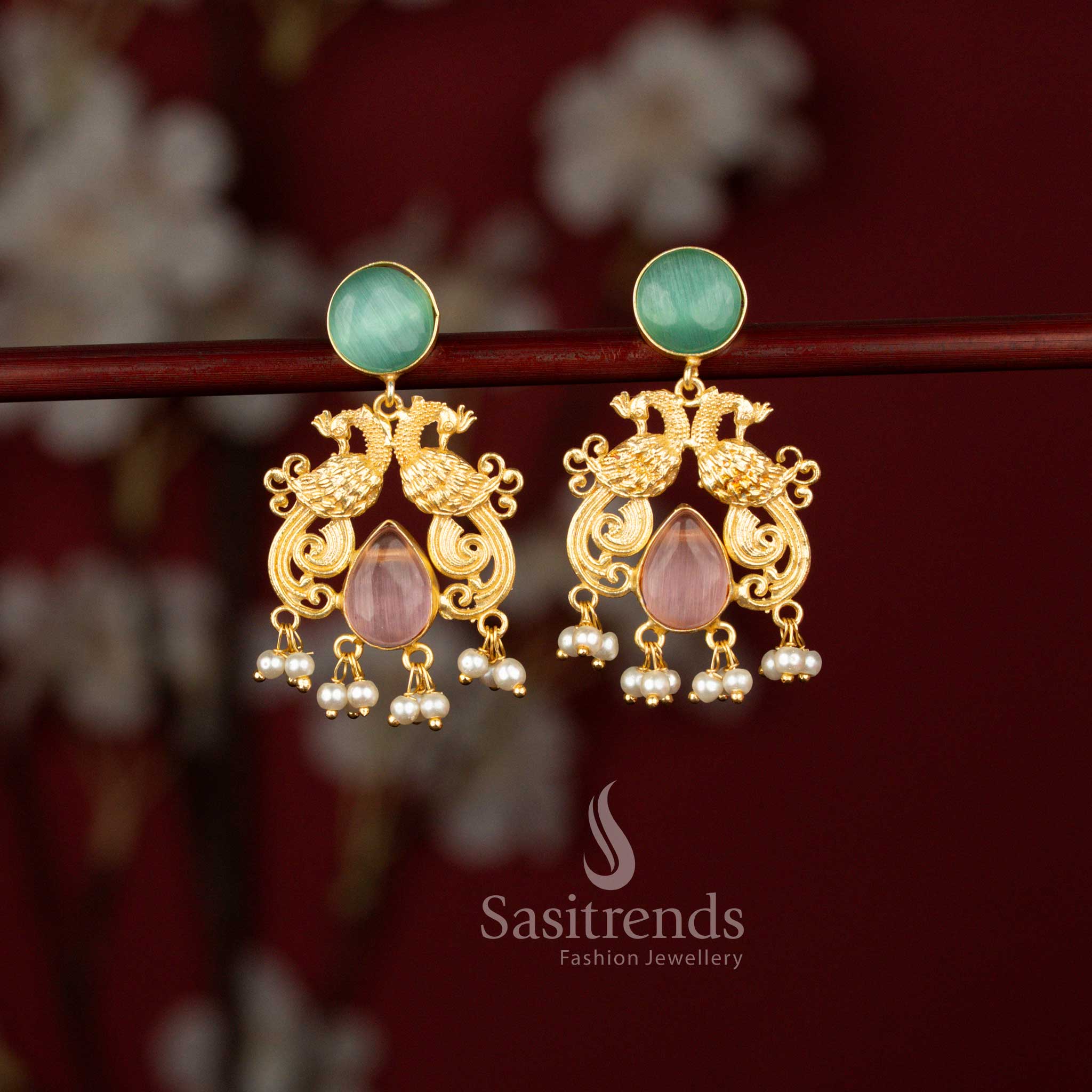 Sasitrends mint pink 24K gold plated dual peacock earrings designed with an ornate circular top, elegant teardrop stone detailing and delicate pearl hangings, perfect for traditional celebrations and festive occasions.