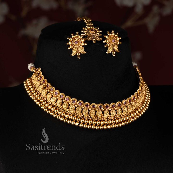 Sasitrends antique gold plated traditional paisley motif broad choker necklace set with intricate repeated motifs, layered bead border, earrings and maang tikka 
