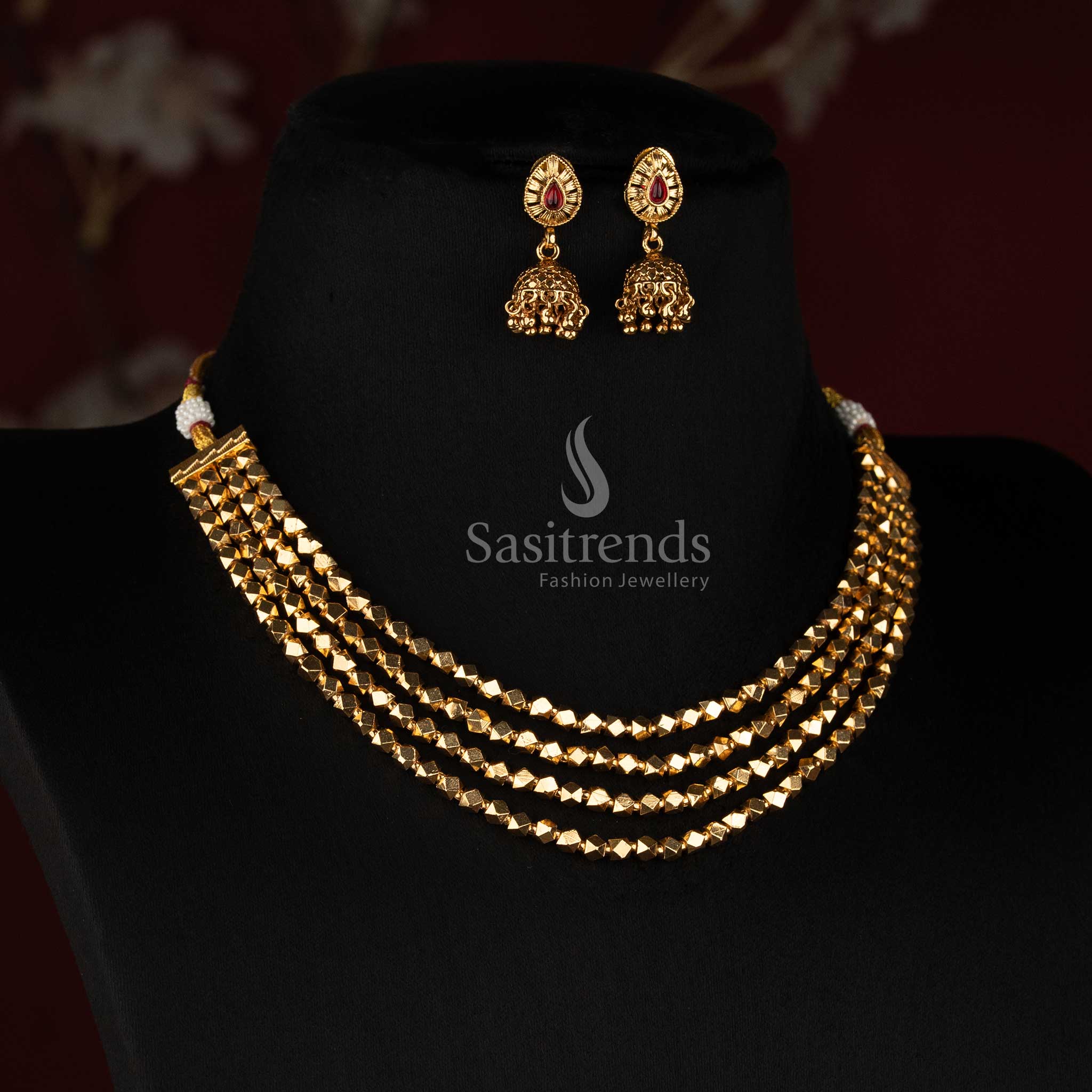 Sasitrends antique gold layered jewellery set with cascading diamond-shaped bead rows, teardrop stone earrings and detailed hanging Jhumka design 