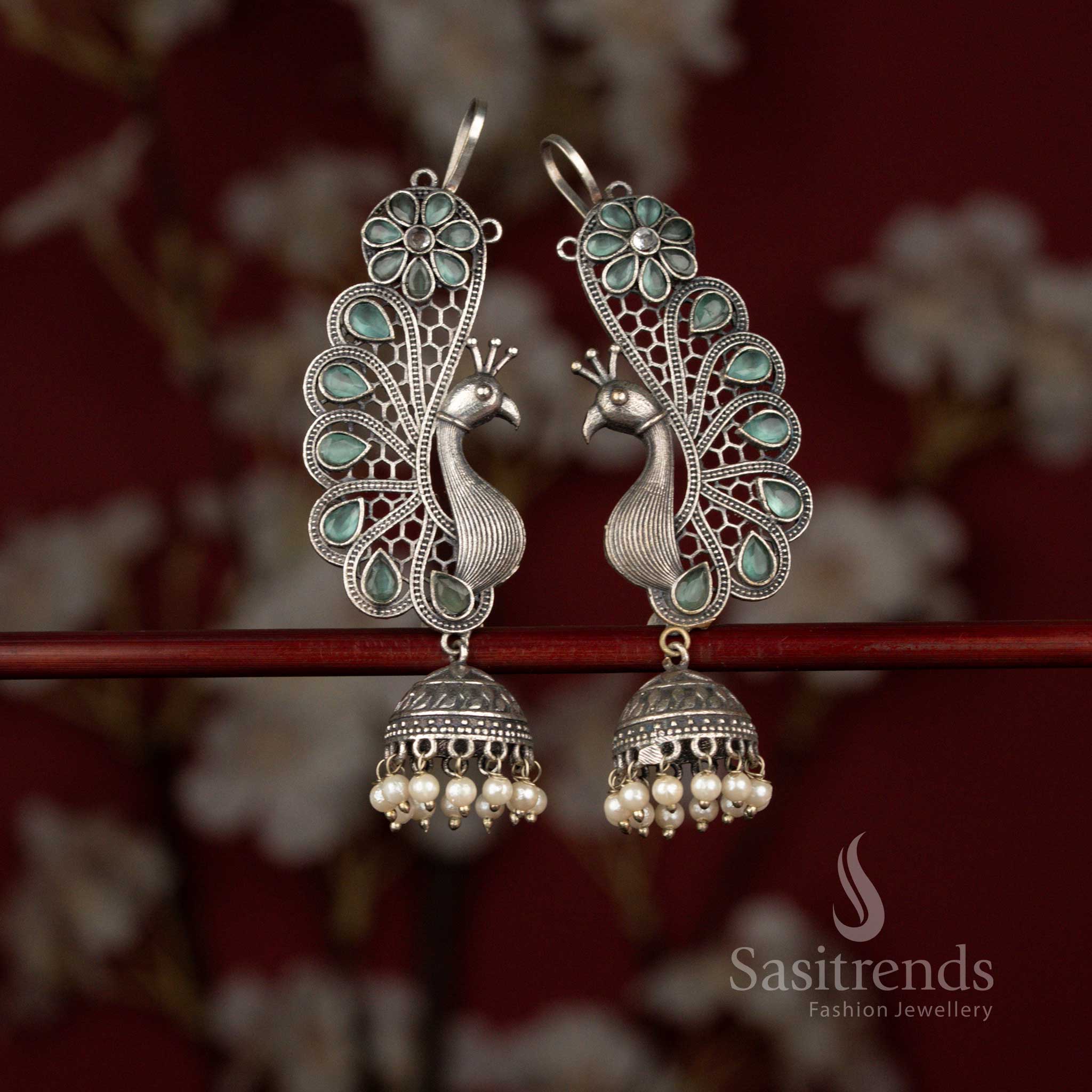 Sasitrends mint 92.5 silver plated antique oxidised earcuff jhumka earrings crafted with an ornate peacock and floral composition, accented by a teardrop stone centerpiece and finished with layered pearl hangings for rich ethnic appeal.