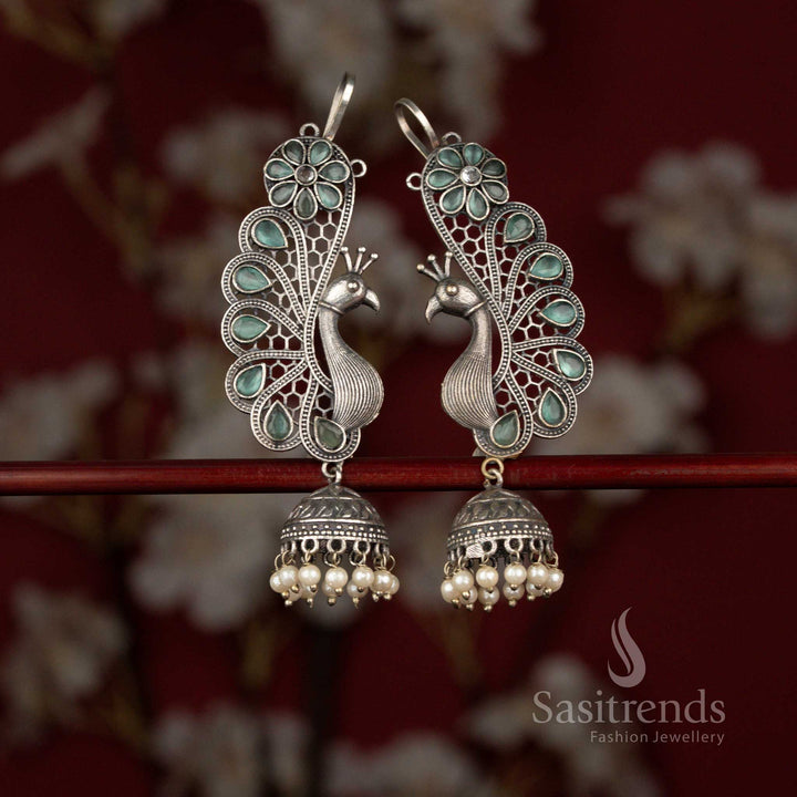 Sasitrends mint 92.5 silver plated antique oxidised earcuff jhumka earrings crafted with an ornate peacock and floral composition, accented by a teardrop stone centerpiece and finished with layered pearl hangings for rich ethnic appeal.
