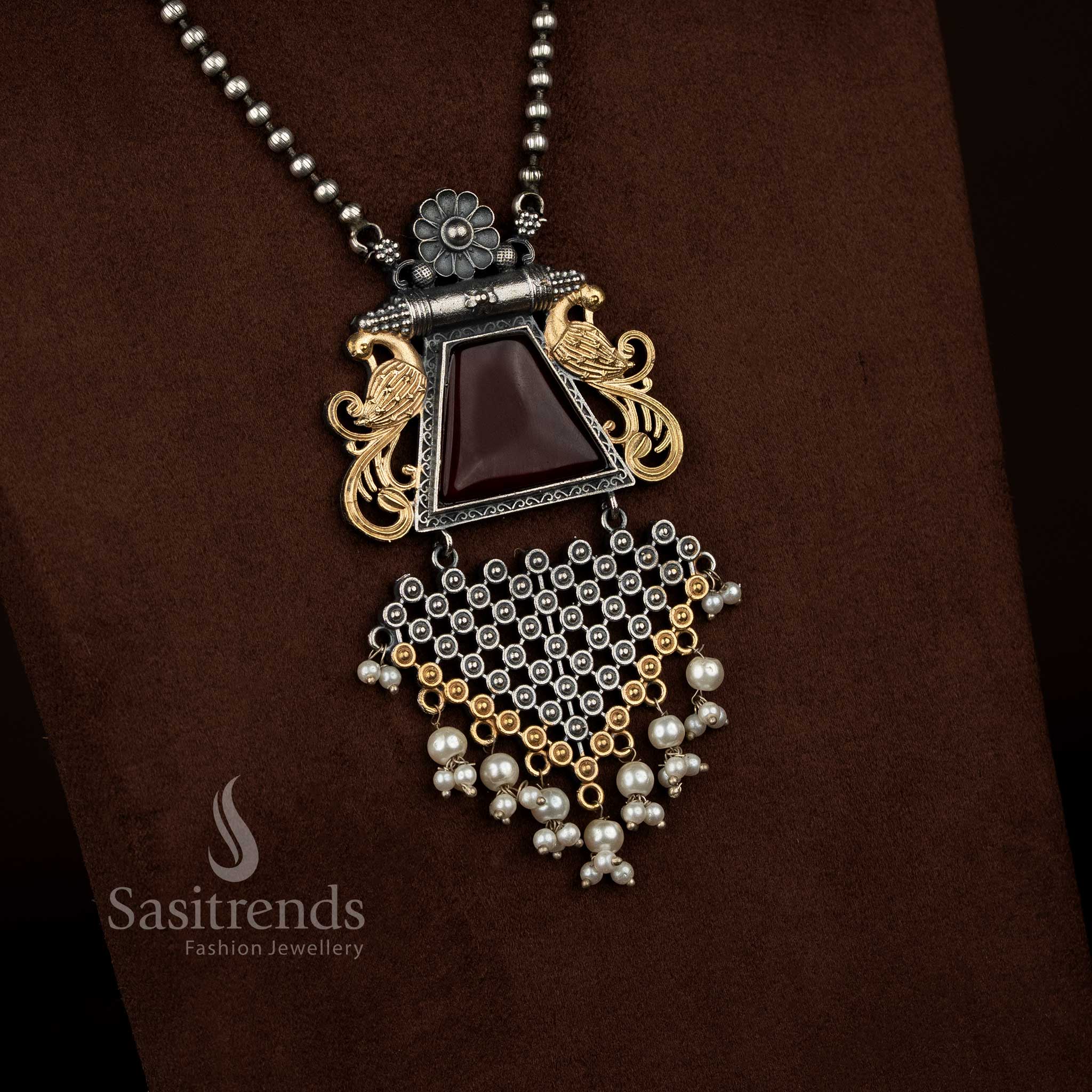 Sasitrends 92.5 silver plated antique oxidised necklace set designed with a red Monalisa stone floral peacock motif pendant, pearl highlights, intricate antique engraving, matching earrings with coordinated design elements, and traditional oxidised chain styling.

