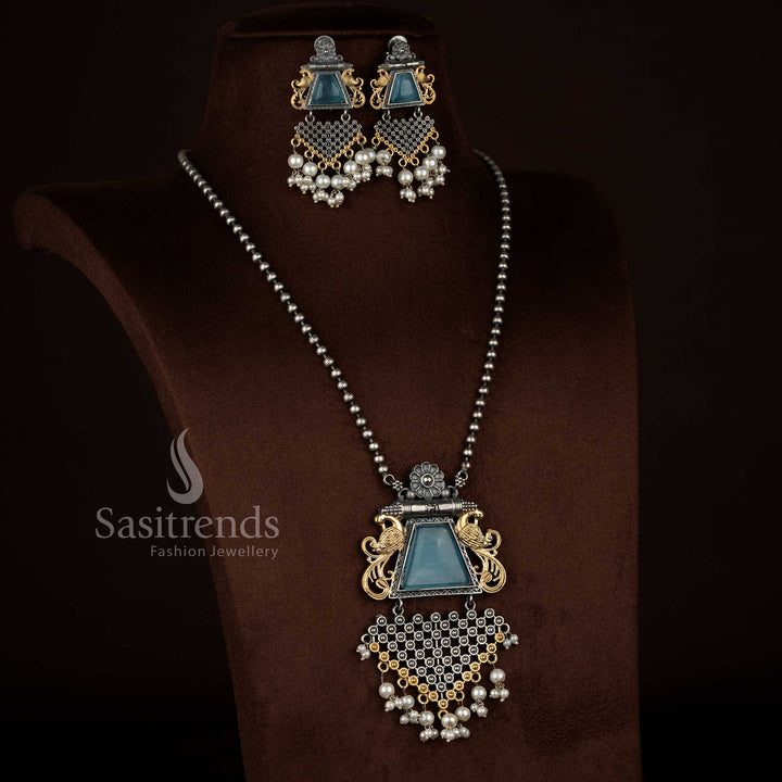 Antique oxidised 92.5 silver plated floral peacock motif pendant chain necklace set by Sasitrends designed with a sky blue Monalisa stone centerpiece, detailed floral carvings, pearl accents, textured antique finish, and matching earrings for traditional jewellery styling.
