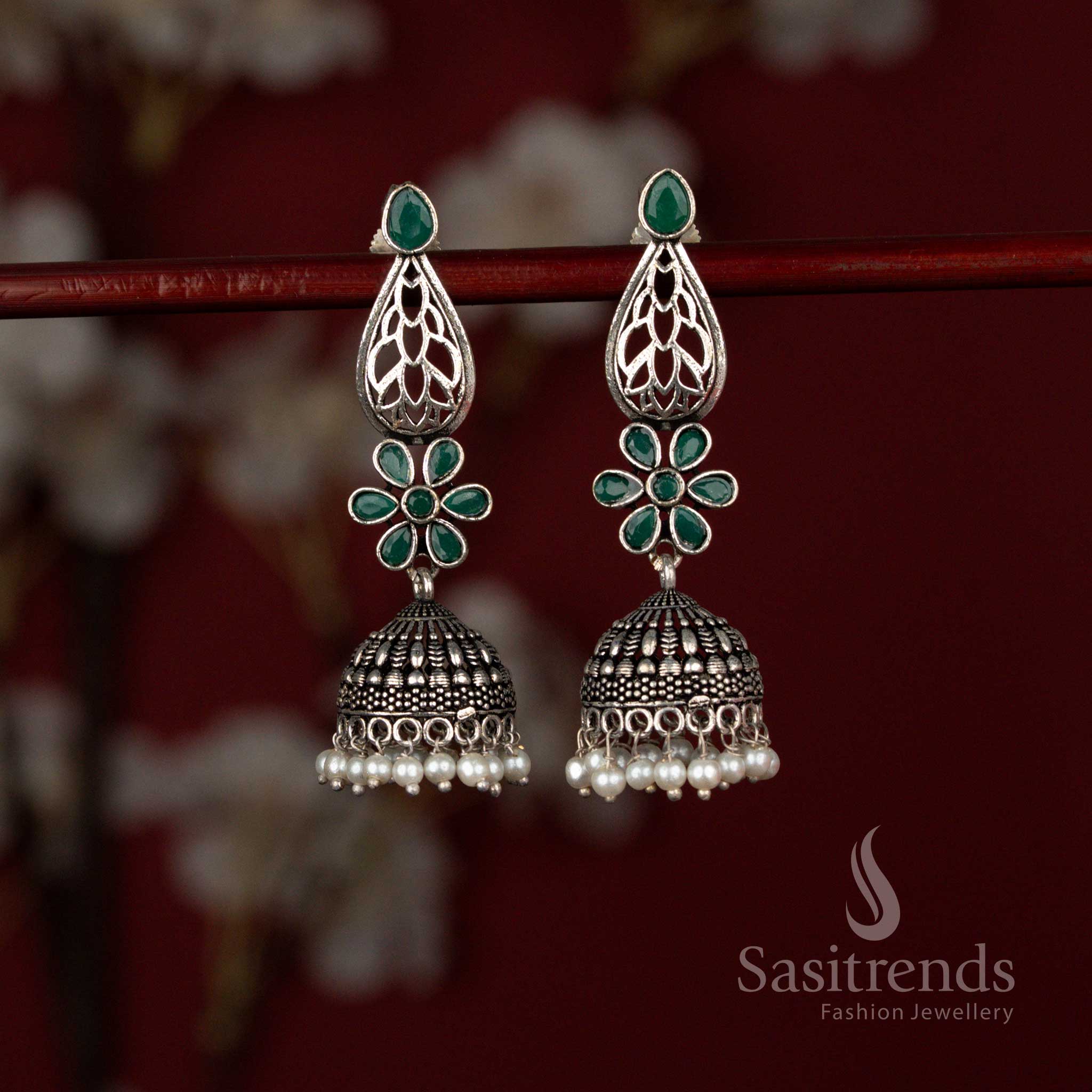Antique style green oxidised German silver earrings from Sasitrends designed with a luminous Monalisa teardrop stone, decorative floral artistry and layered pearl jhumka drops ideal for traditional celebrations.