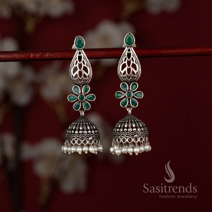 Antique style green oxidised German silver earrings from Sasitrends designed with a luminous Monalisa teardrop stone, decorative floral artistry and layered pearl jhumka drops ideal for traditional celebrations.