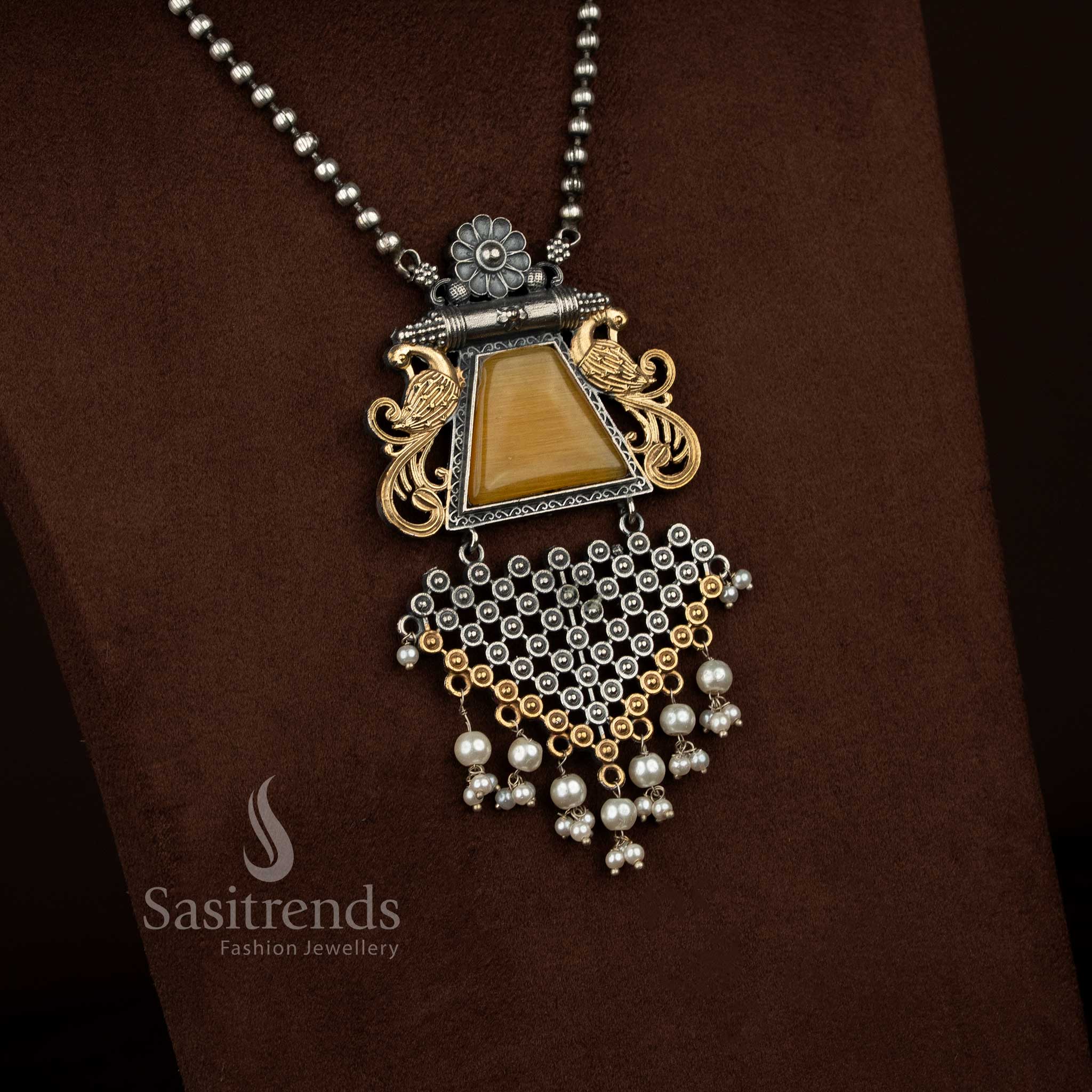 Antique oxidised silver plated floral peacock motif necklace set by Sasitrends showcasing a statement pendant with smooth Monalisa stone centerpiece, sculpted floral elements, pearl detailing, heritage oxidised finish, matching earrings reflecting the same design theme, and a complementary silver plated chain.