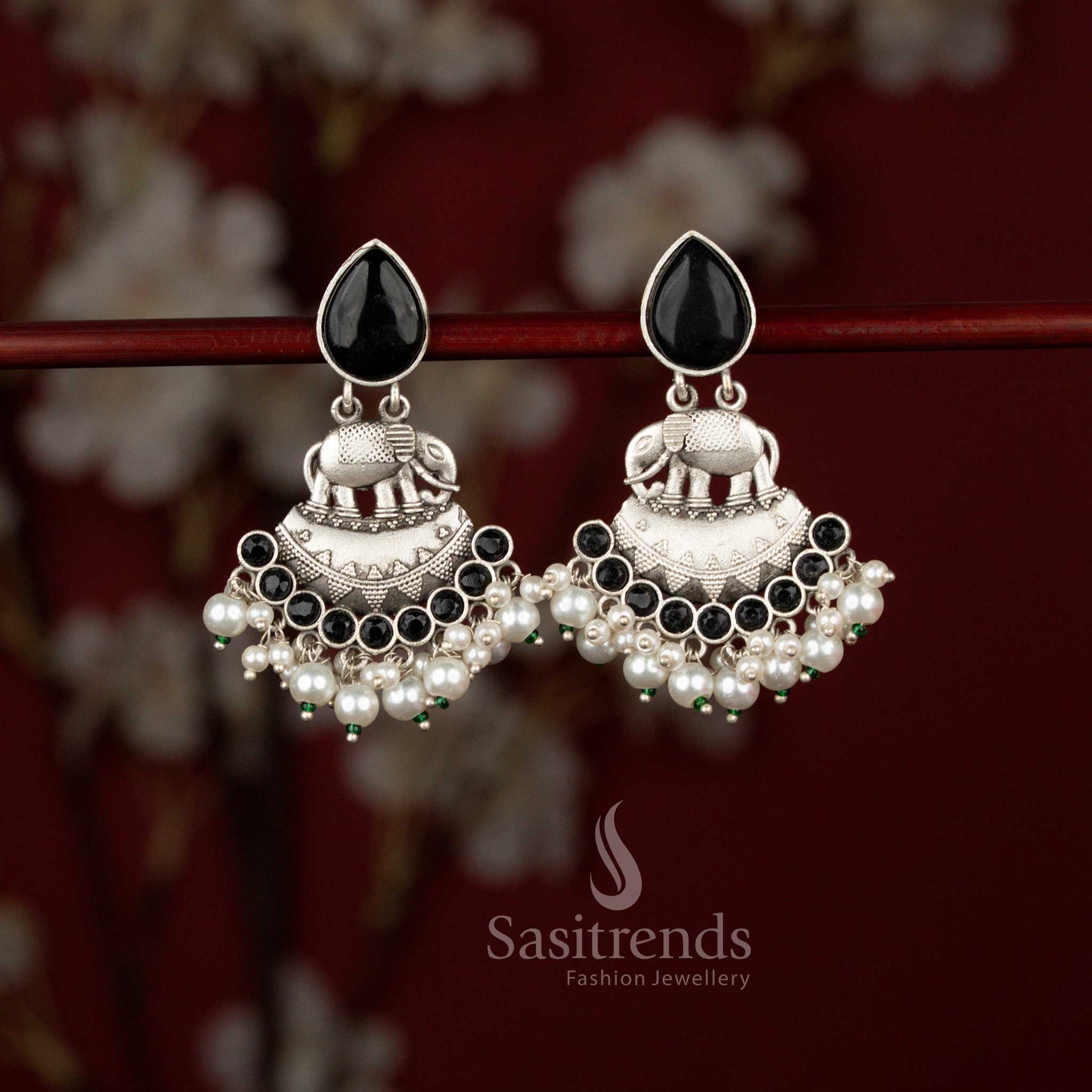 Sasitrends antique finish oxidised silver elephant earrings crafted in a curved crescent silhouette, adorned with radiant teardrop stones and layered pearl drops, perfect for ethnic celebrations and traditional occasions.