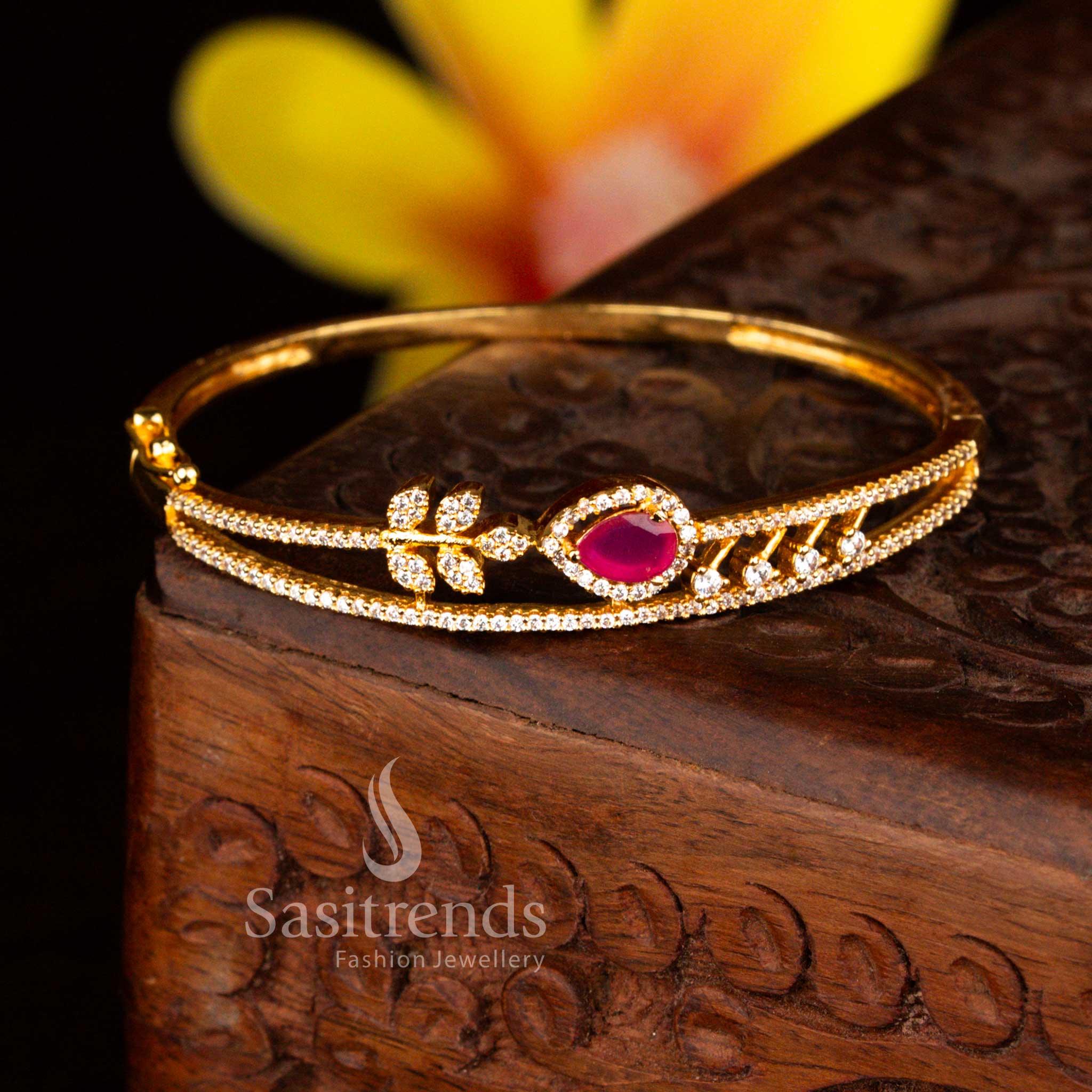 Sasitrends bridal micro gold plated floral teardrop white ruby American diamond openable kada bangle designed with premium stone embellishments and rich gold lustre finish.