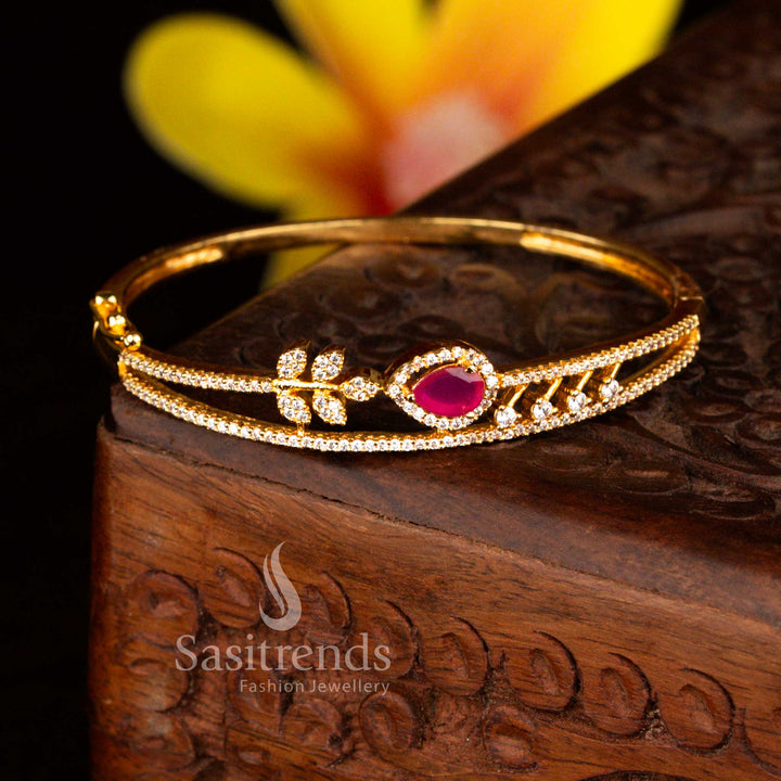 Sasitrends bridal micro gold plated floral teardrop white ruby American diamond openable kada bangle designed with premium stone embellishments and rich gold lustre finish.