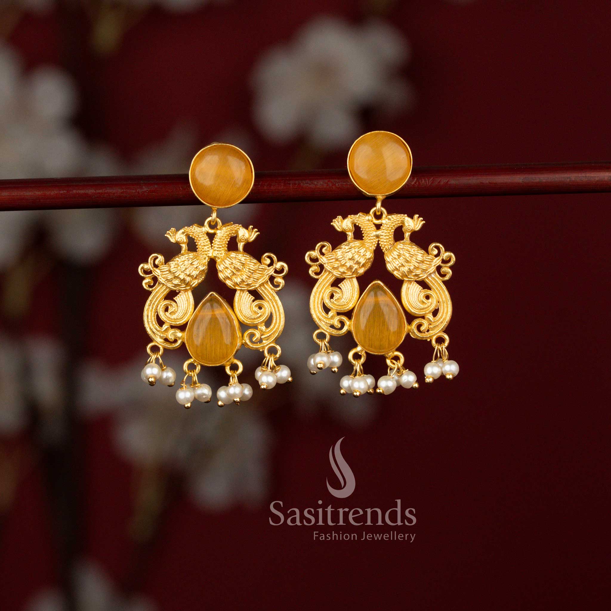Sasitrends elegant 24K gold plated dual peacock earrings featuring a finely crafted circular top, radiant teardrop yellow stone accents and cascading pearl drops, beautifully suited for traditional celebrations and cultural functions.