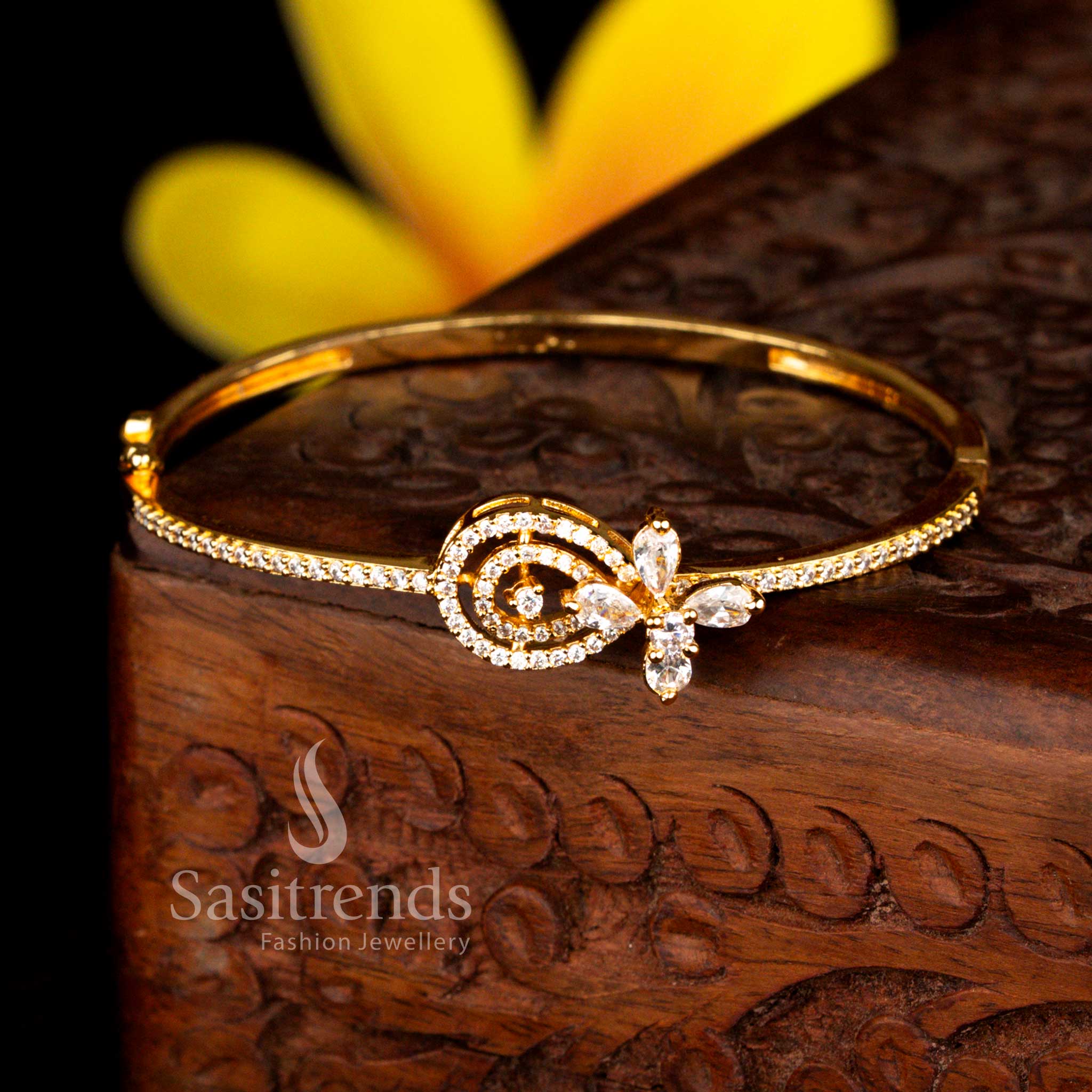 Sasitrends exclusive micro gold plated swirl motif floral accent white American diamond openable kada bracelet featuring premium gold tone finish and sparkling stone detailing.