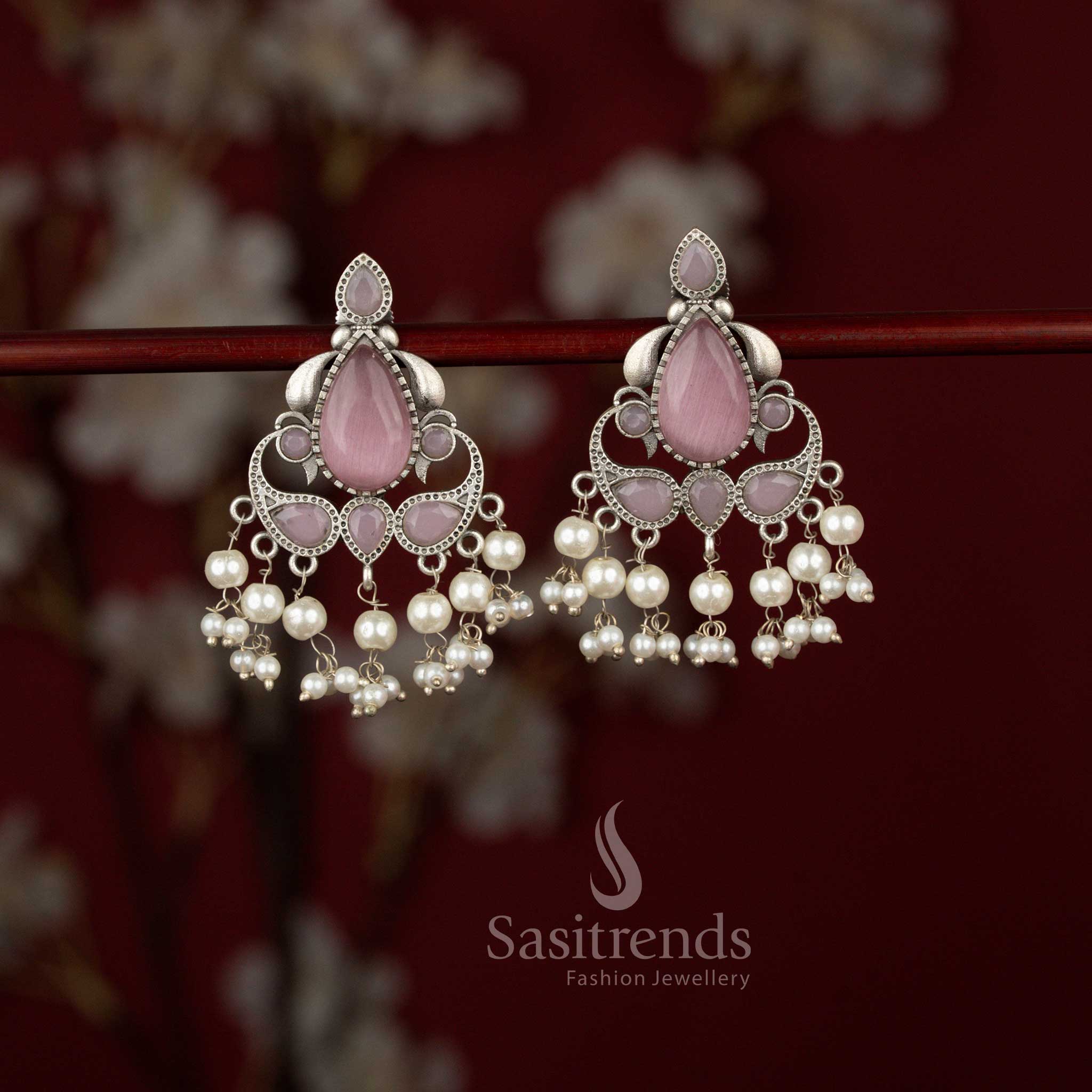 Grand Peacock pink Eleganza oxidised silver earrings from Sasitrends featuring a beautifully carved peacock design, shimmering teardrop stone elements and pearl embellishments that enhance sarees and traditional outfits.