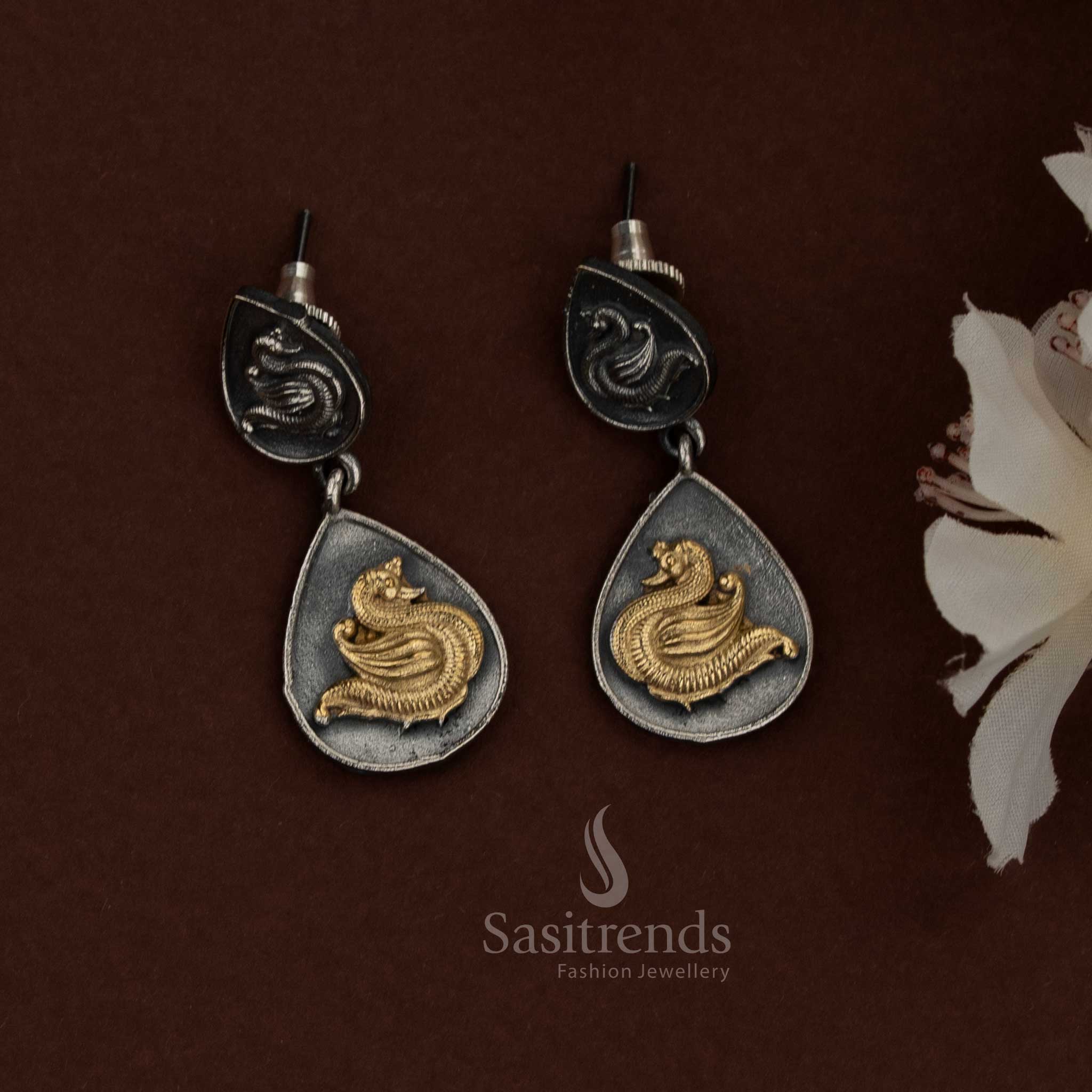 Sasitrends 92.5 dual tone silver oxidised husli necklace jewellery set featuring a bold crescent-shaped segmented panel design with embossed peacock motifs on each section, layered teardrop danglers suspended along the lower edge, textured oxidised surface detailing, traditional thread fastening, and matching earrings with coordinated peacock motif drop design for ethnic heritage styling.