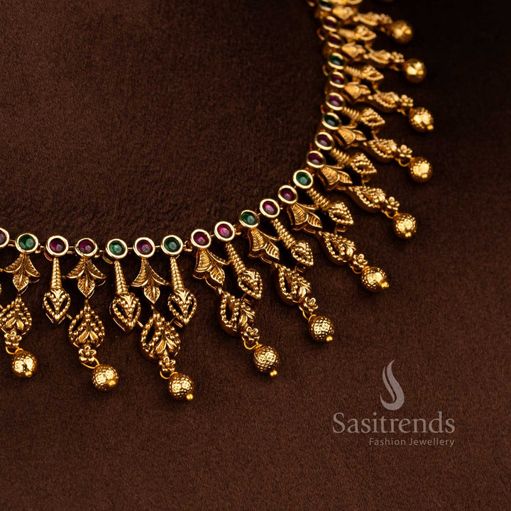 Sasitrends leaf motif temple necklace jewellery set finished in matte gold plating with fine ruby green AD stone work and traditional hanging bead design