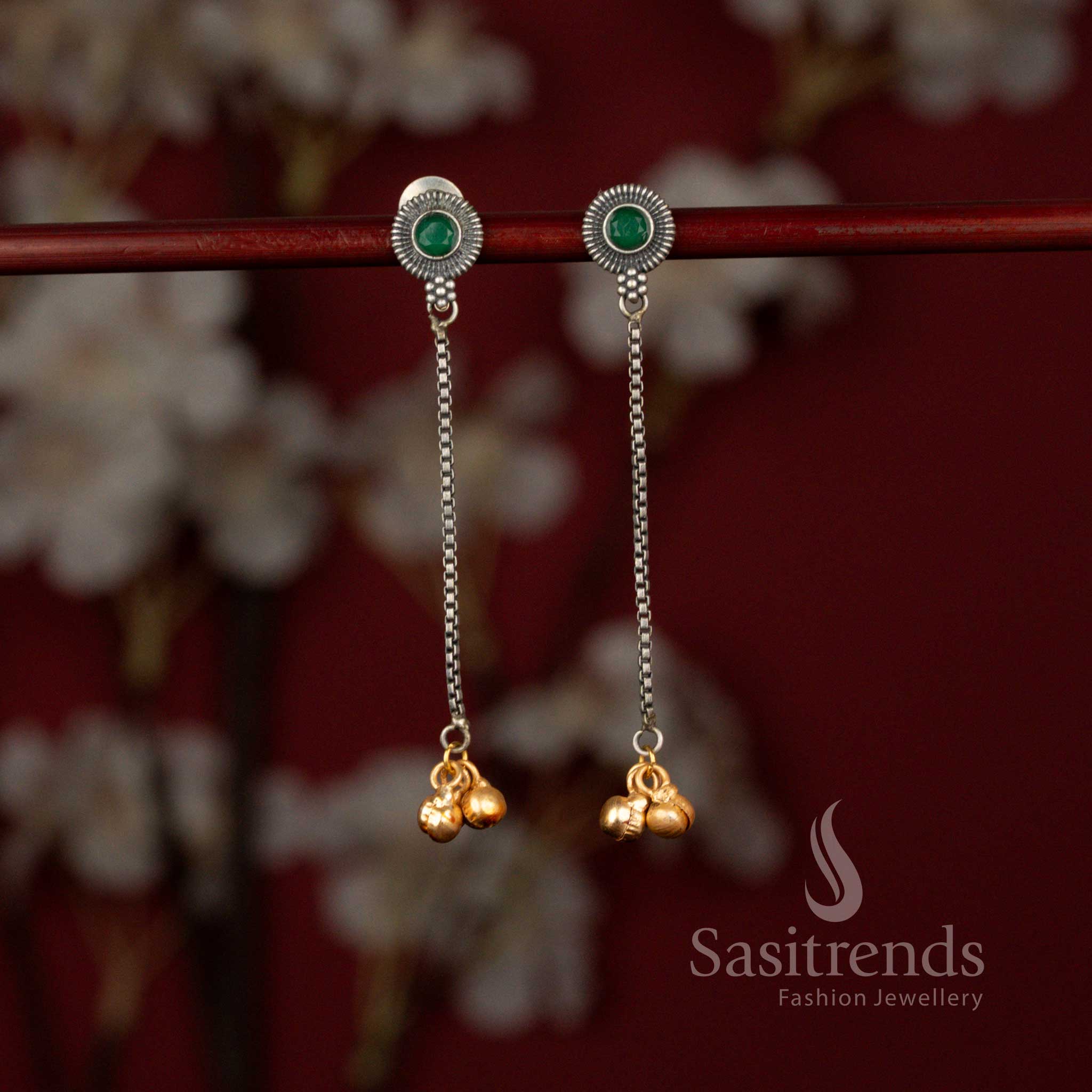Elegant oxidised 92.5 silver plated earrings from Sasitrends designed with a detailed sunburst green stone top, flowing linear chain structure and subtle golden bead embellishments perfect for sarees and festive outfits.