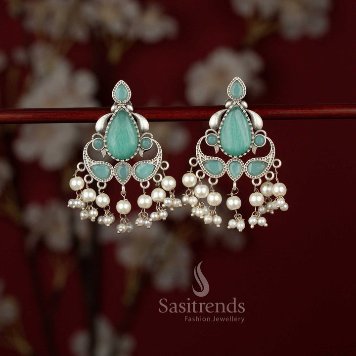 Elegant mint oxidised silver peacock dangler earrings from Sasitrends designed with a detailed feather motif, highlighted teardrop stone centerpiece and soft pearl accents perfect for festive gatherings and cultural events.