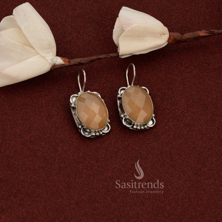 Sasitrends polished oxidised German silver earrings designed with oval faceted peach stone and refined floral frame structure