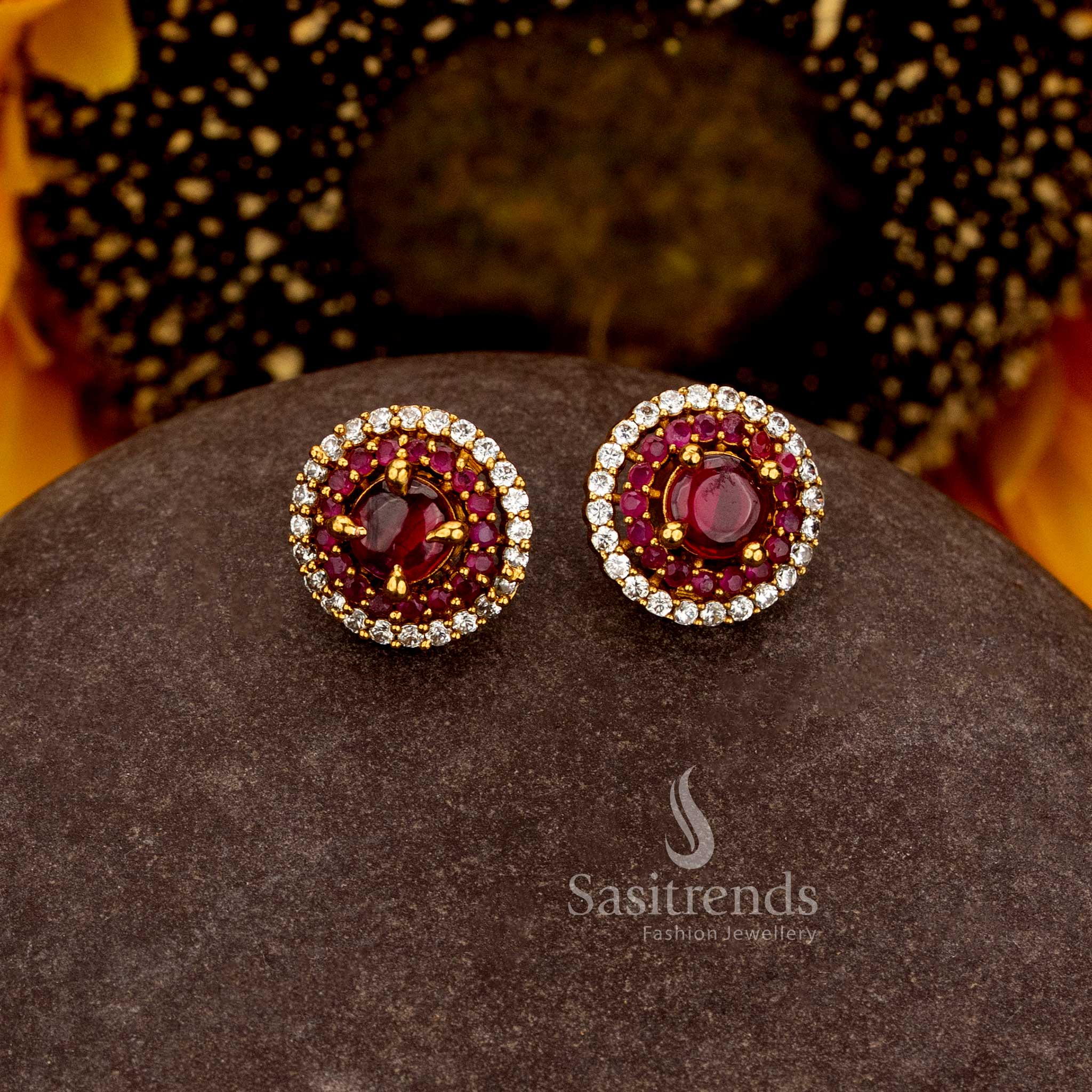 Sasitrends premium temple matte gold plated AD stone round stud earrings featuring a prominent central round stone, intricate layered inner detailing and a continuous outer stone border 