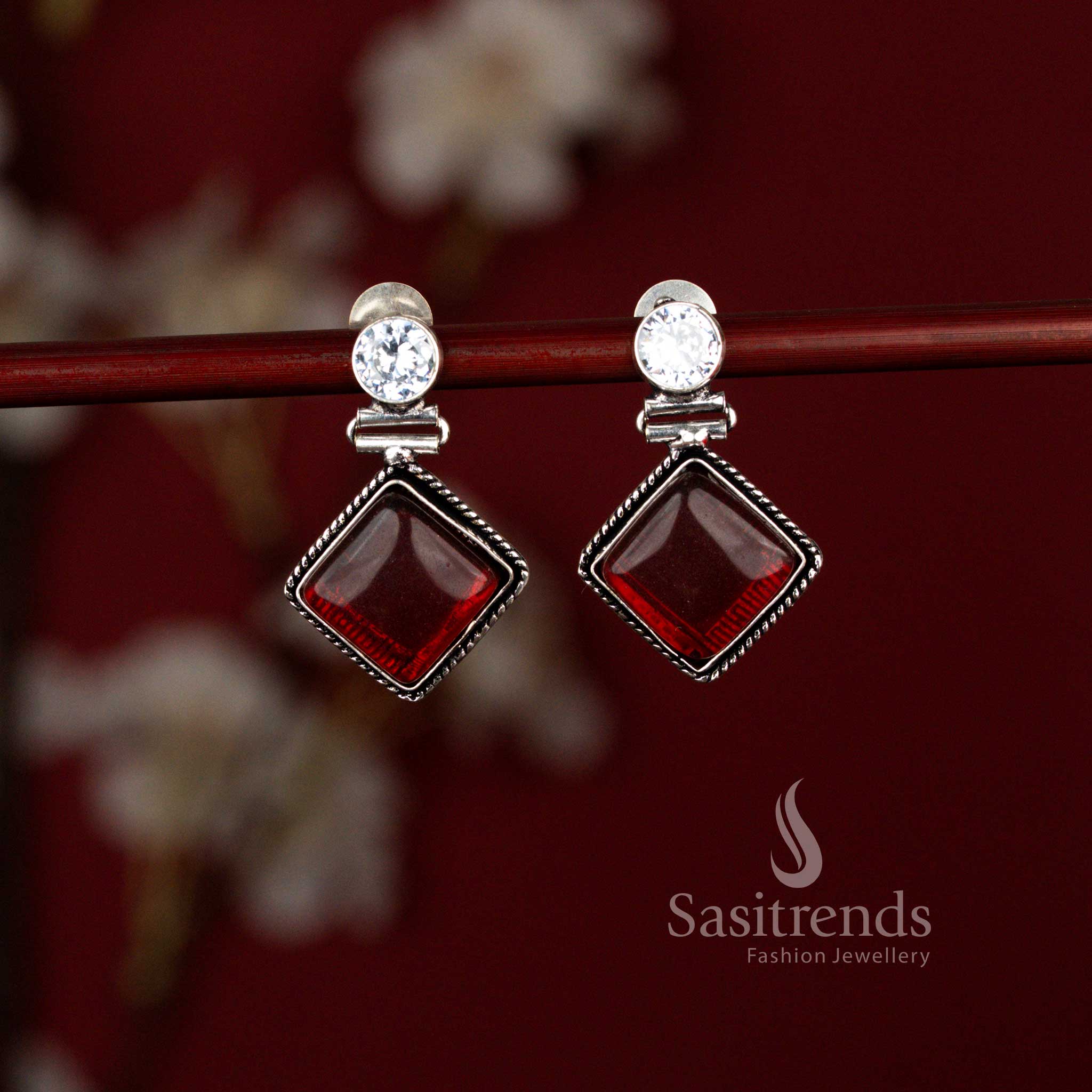 Sasitrends red oxidised silver rhombus dangle earrings crafted with a smooth Monalisa stone in an eye motif setting, offering a balanced blend of contemporary office style and semi-ethnic charm.