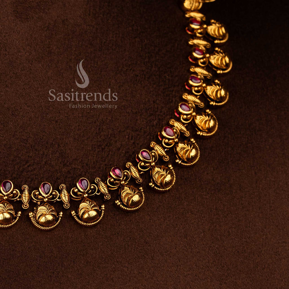 Sasitrends temple style matte gold plated floral leaf motif necklace set with ruby AD stones and hanging gold beads offering a rich traditional and premium temple wear look