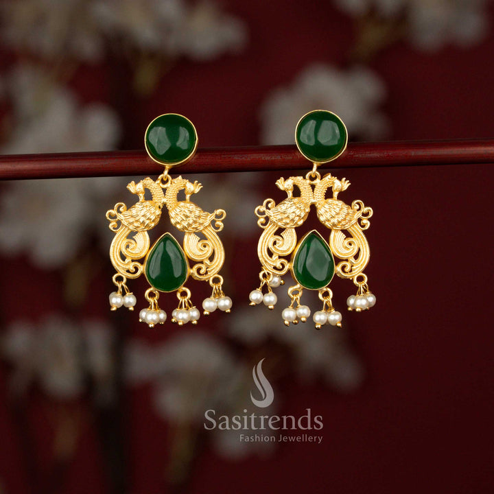 Traditional green 24K gold plated dual peacock earrings from Sasitrends featuring a circular motif, sparkling teardrop stones and graceful pearl drops that enhance sarees and ethnic wear beautifully.