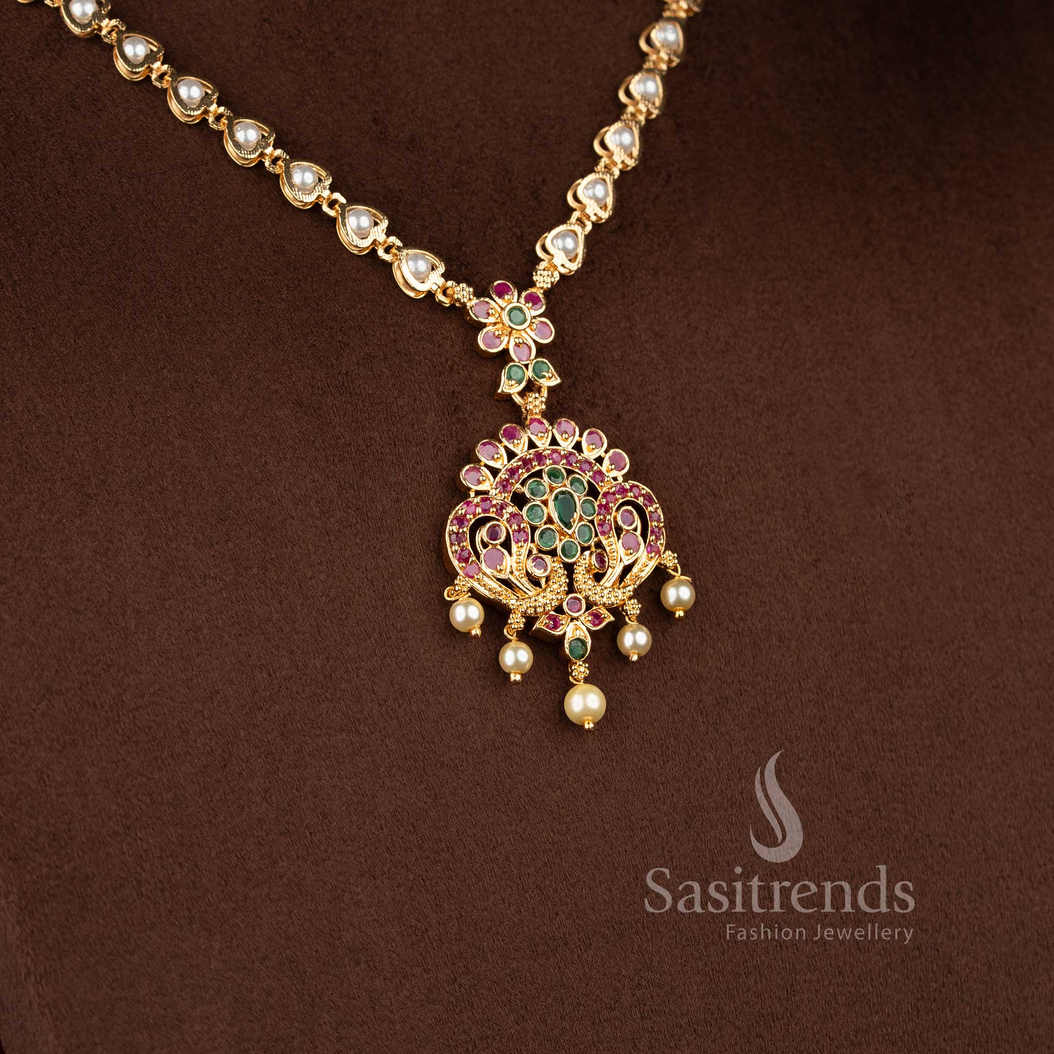 Sasitrends traditional micro gold plated peacock floral necklace jewellery set designed with pearl accents and ruby green AD stone embellishments for ethnic wear