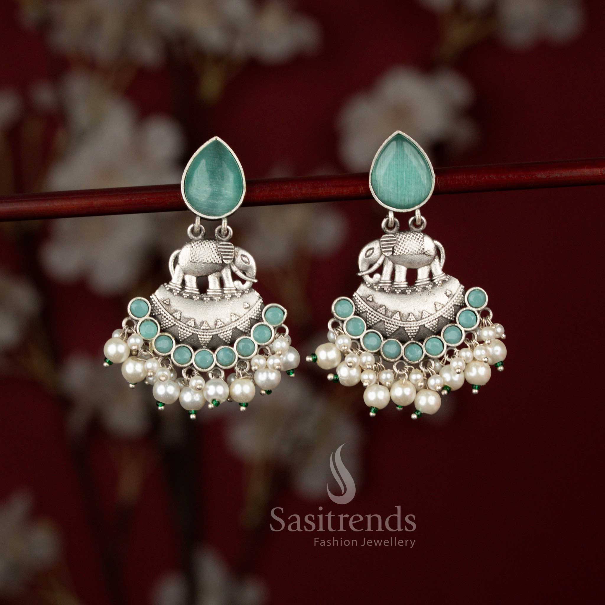 Traditional mint oxidised silver elephant crescent earrings from Sasitrends crafted with intricate metal detailing, luminous teardrop stone accents and layered pearl drops that enhance festive attire and cultural celebration wear.