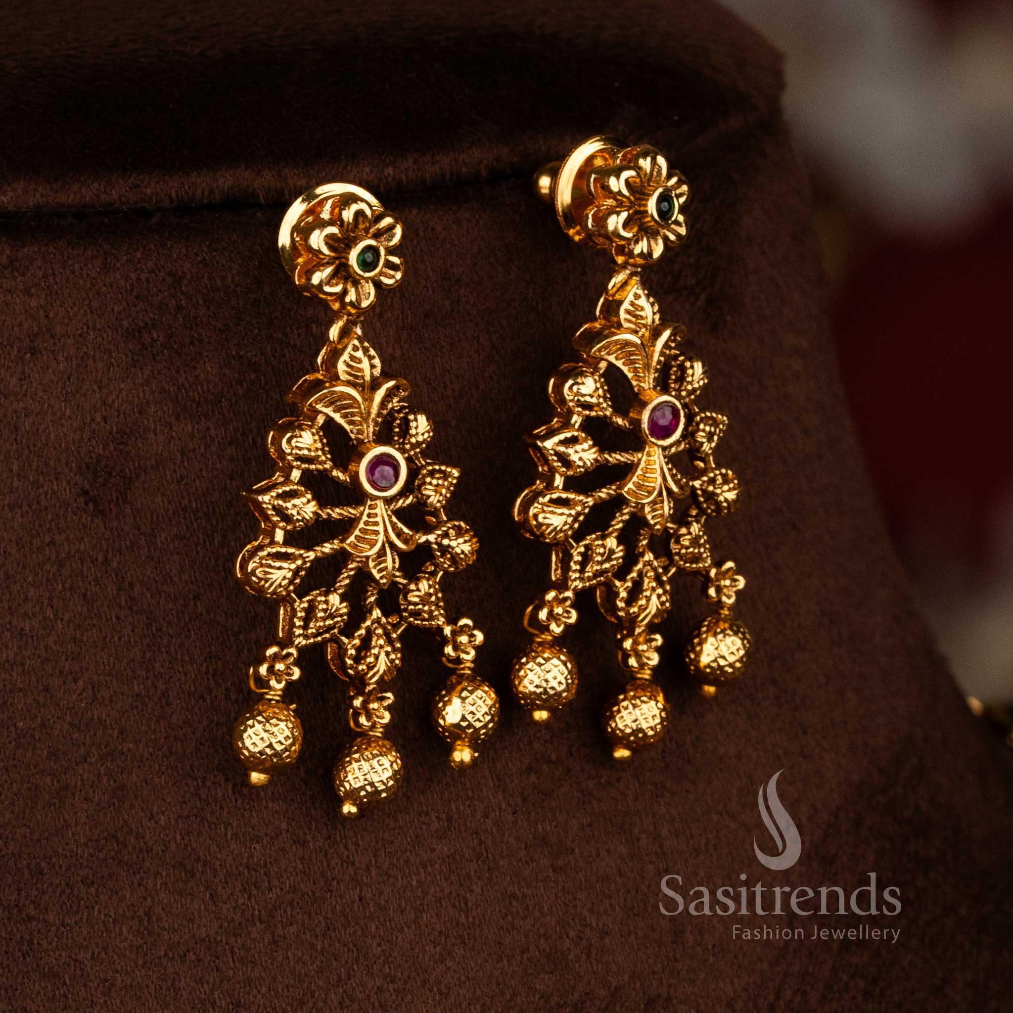 Sasitrends traditional saree wear temple necklace set featuring matte gold finish, ruby green AD stones, carved leaf design, and rich bead hangings