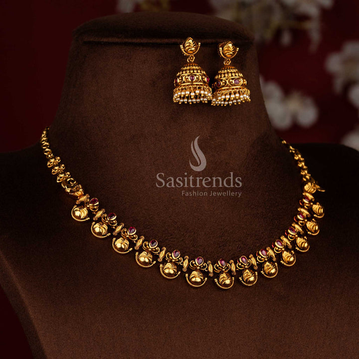 Sasitrends traditional South Indian temple jewellery necklace set featuring floral and leaf design, matte gold finish, ruby AD stone embellishments, and matching jhumka earrings