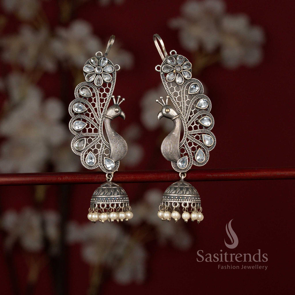 Elegant white oxidised 92.5 silver plated earcuff jhumka earrings from Sasitrends crafted with a graceful peacock motif, floral detailing, teardrop stone accents and pearl drops ideal for silk kurtis and festive occasions.