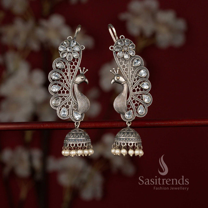 Elegant white oxidised 92.5 silver plated earcuff jhumka earrings from Sasitrends crafted with a graceful peacock motif, floral detailing, teardrop stone accents and pearl drops ideal for silk kurtis and festive occasions.
