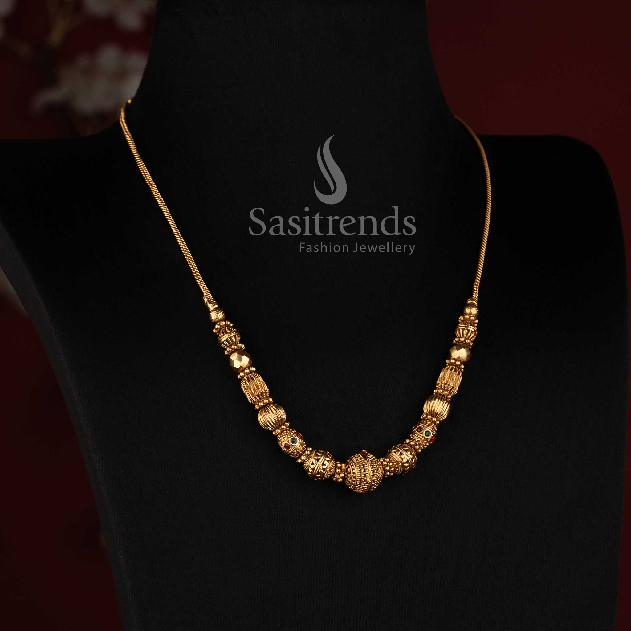 Elegant Sasitrends matte gold temple jewellery necklace with textured spherical bead arrangement, ornate cylindrical elements and distinctive central ball detail