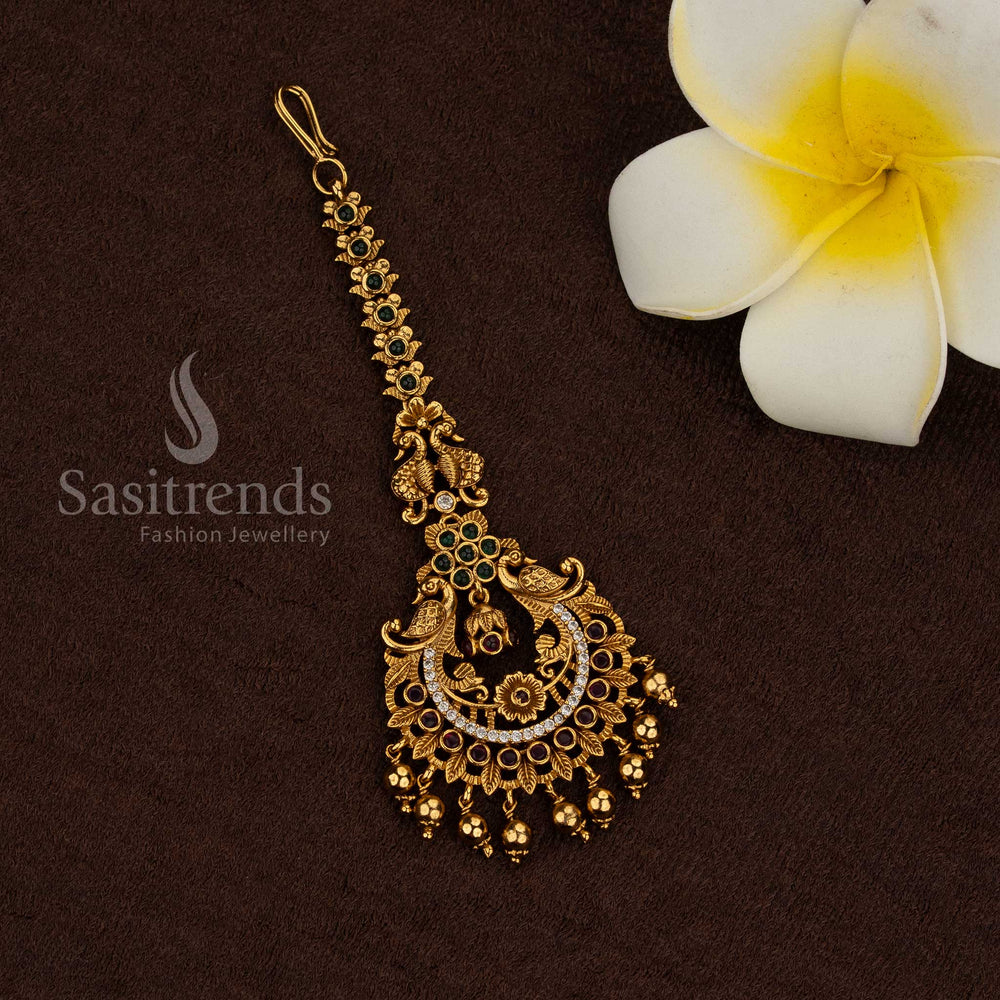 Temple matte gold plated peacock motif maang tikka with multi kemp AD stone detailing and hanging bead drops, rich premium look ideal for bridal, wedding, and temple wear - Sasitrends
