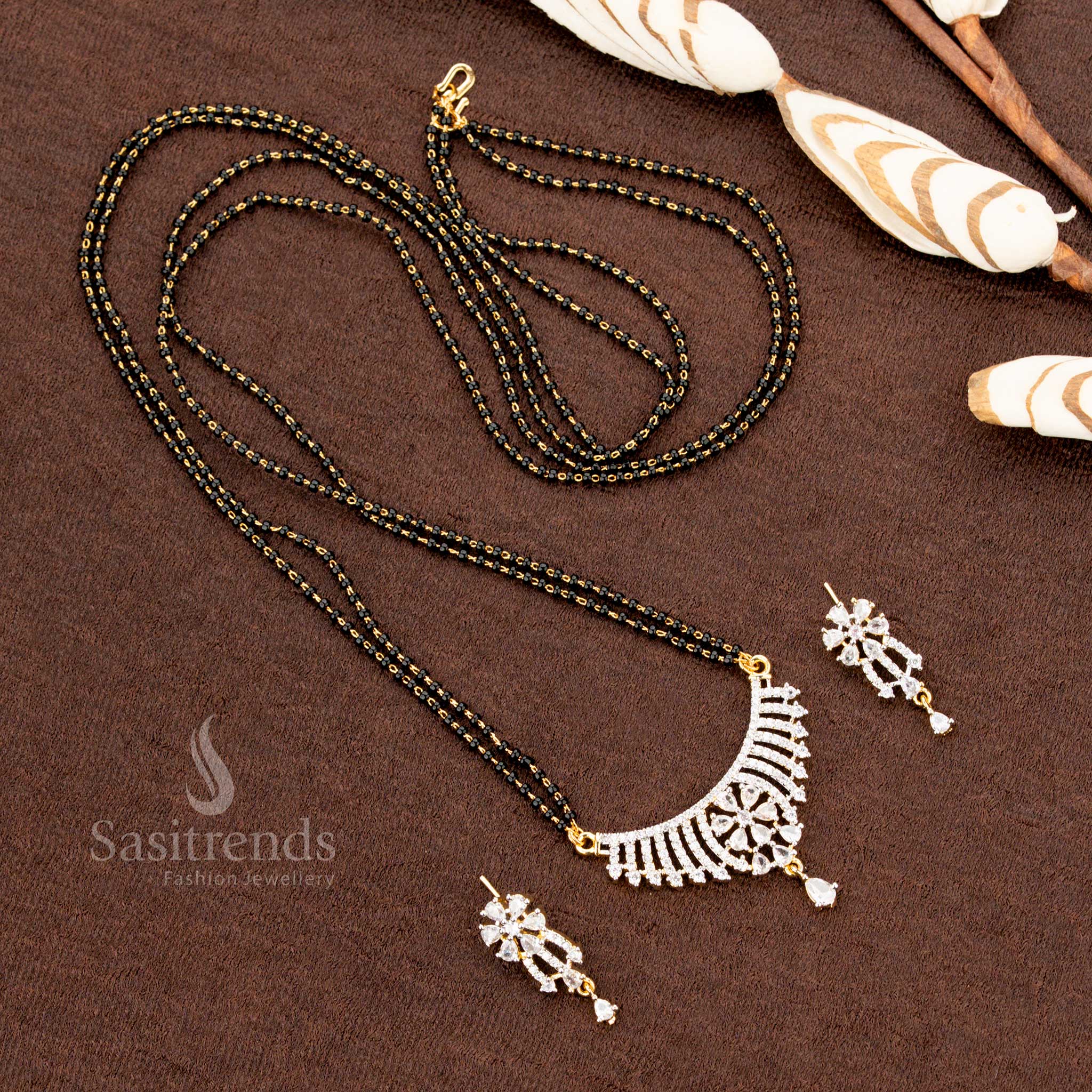 Dazzling white AD pendant set with an intricate floral pattern, paired with a micro gold plated Mangalsutra chain and earrings, a premium jewellery piece for special occasions - Sasitrends