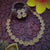 Close-up of Leaf Chakara Pattern Necklace Set: Ruby Stone Center Encircled by White Stones, Brass Material with Matte Gold Finish